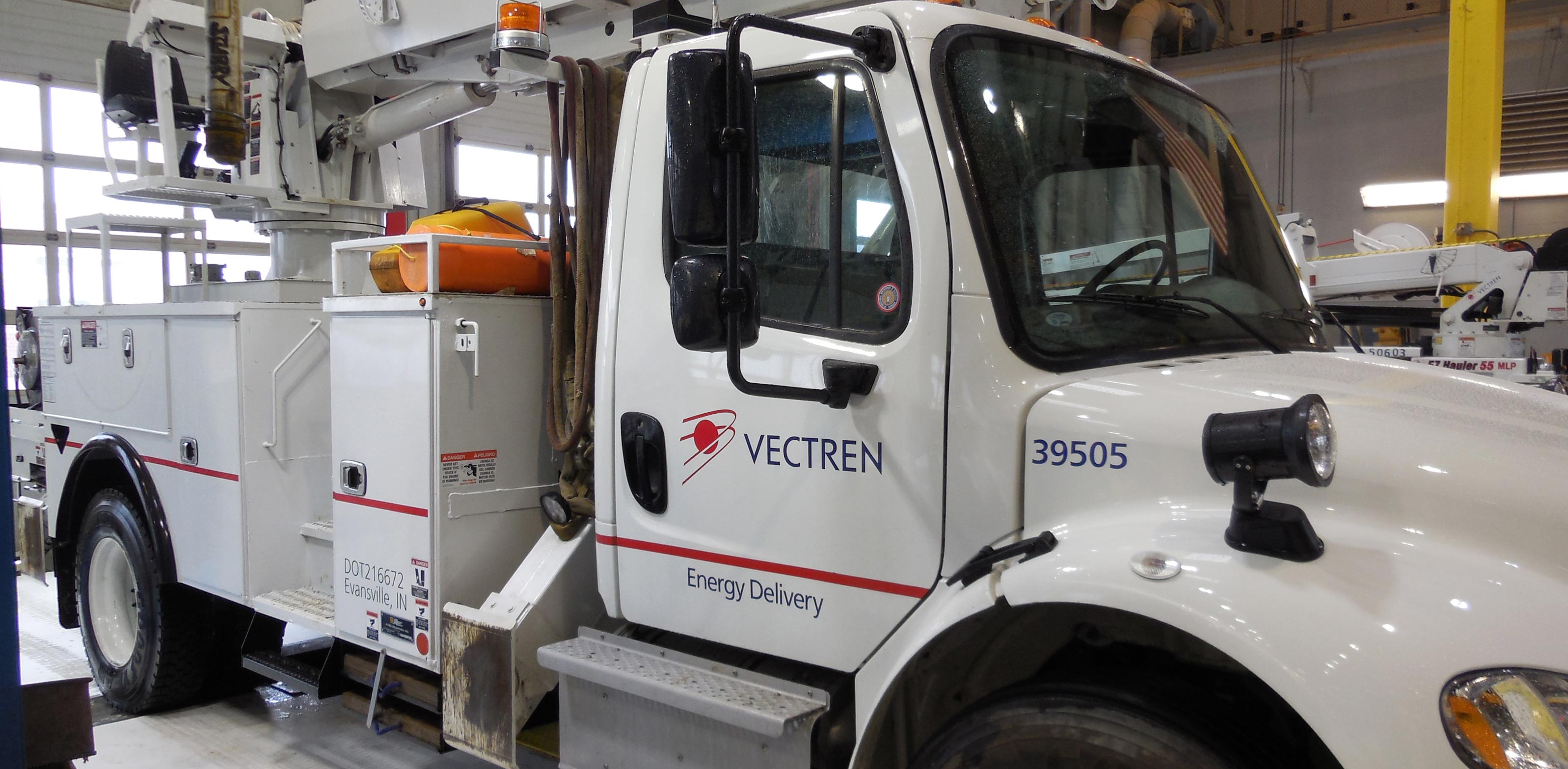 A Vectren utility truck with a ladder parked in the garage